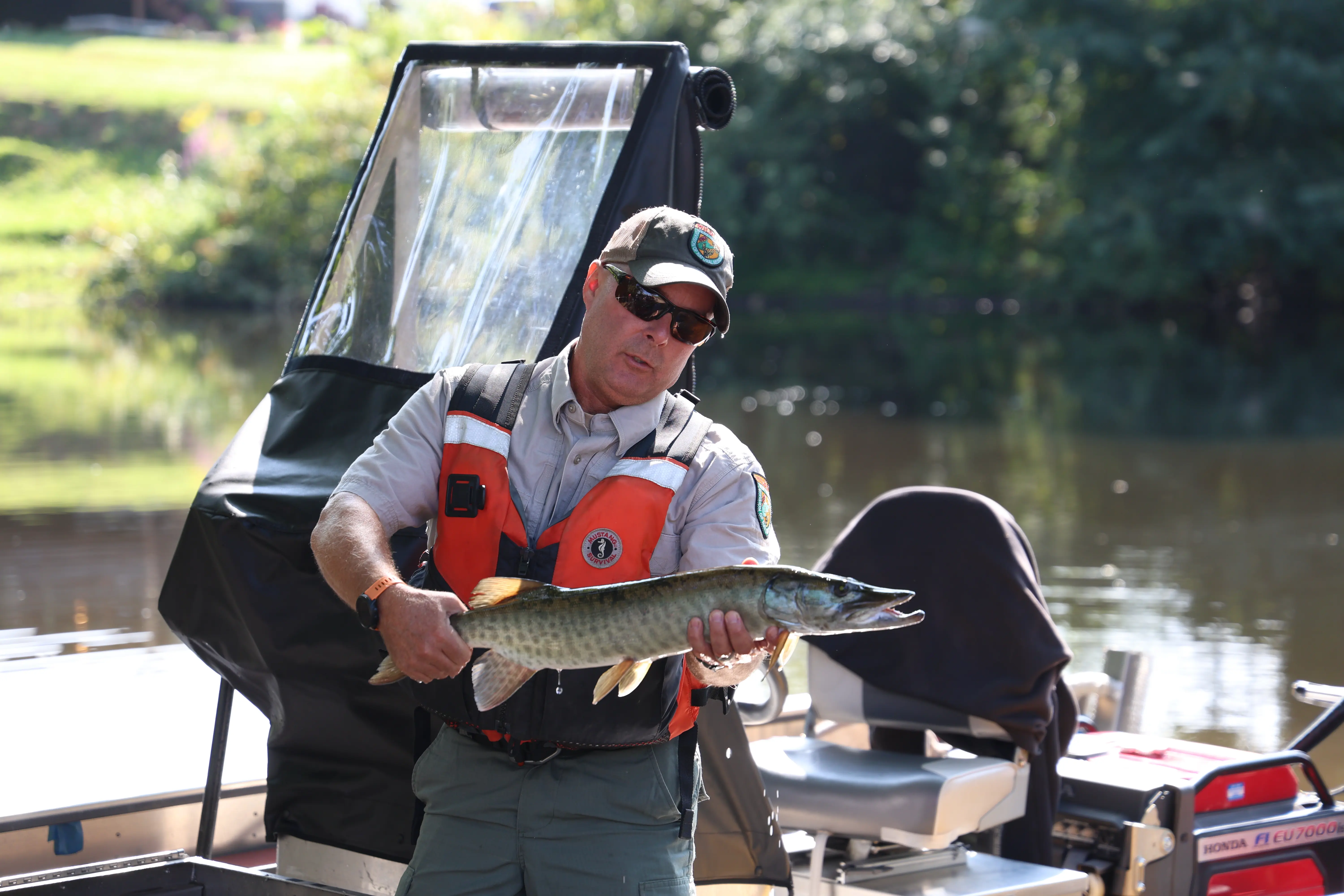 A fisher holding a musky